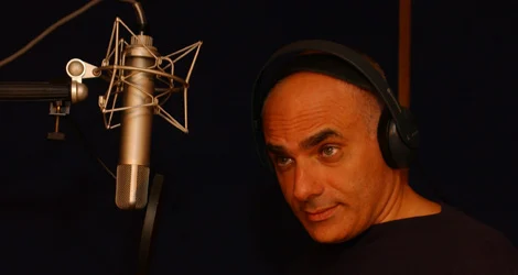 Maurizio Modica in cabina con le cuffie, davanti al microfono